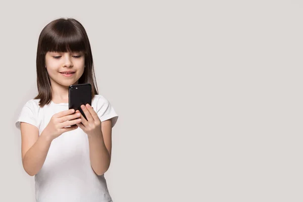 Close up portrait with smiling little brown-haired girl with cellphone. — Stock Photo, Image