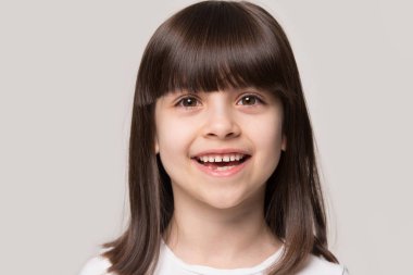 Gülümseyen kahverengi saçlı bir kızın yakın portresini çek.