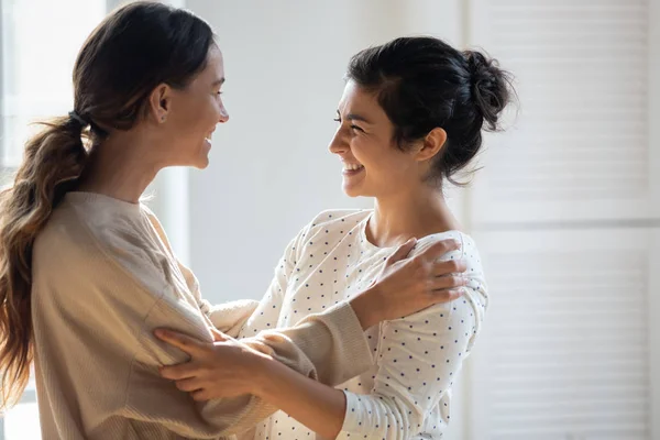 Two mixed race girls cuddling, enjoying communicating together. — Stock Photo, Image