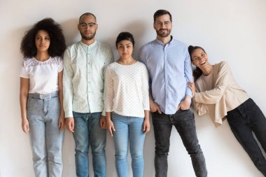 Çok ırklı insanlar kameraya bakıyor, farklı karakter özellikleri gösteriyor..