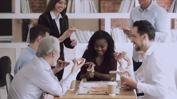 Mutlu çok ırklı genç ve yaşlı iş adamları ofiste pizzayı paylaşıyor. — Stok video