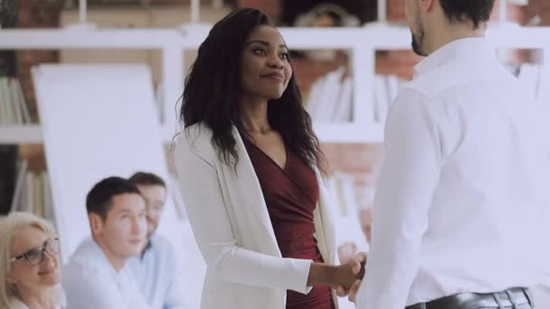 Usmívající se černošky žena zaměstnanec dostat odměněn handshake běloch šéf — Stock video