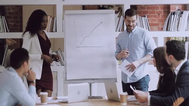 Two diverse business coaches working together give flip chart presentation — Stock Video