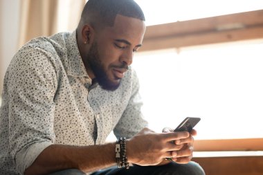 Cep telefonu mesajlaşması ya da web tarayıcısı kullanan Afrikalı Amerikalı bir adam
