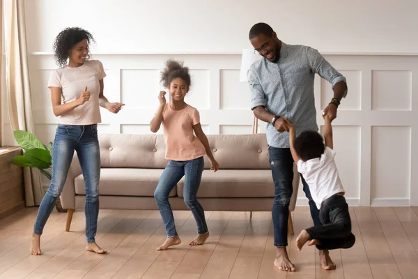 African couple and little kids dancing together at home — Stock Photo, Image