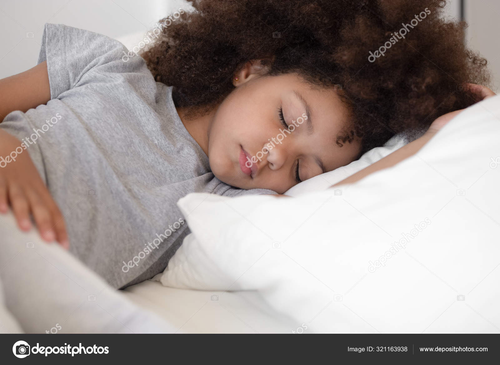 Calm Little Biracial Girl Sleeping Peacefully In White Bed Stock