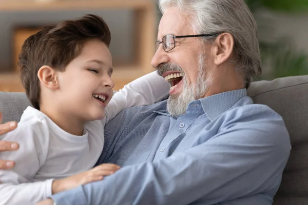 Buon nonno ridente che gioca, abbracciando adorabile nipotino — Foto Stock