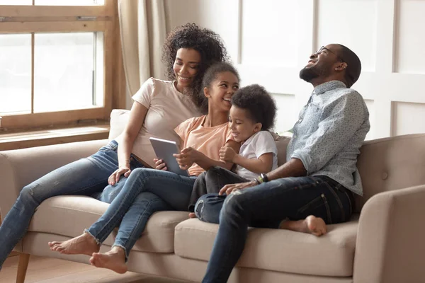 Tablet bilgisayar kullanan neşeli melez bir aile. — Stok fotoğraf