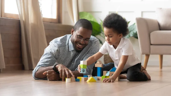 非洲父亲和儿子在地板上玩玩具块 — 图库照片