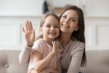 Mutlu anne ve küçük kız el sallayan kameraya bakın.