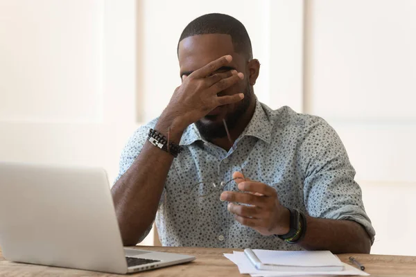 Erschöpfter Mann nimmt Brille ab und leidet unter Kopfschmerzen — Stockfoto