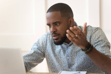 Kızgın Afrikalı Amerikalı adam dizüstü bilgisayarla karıştırılmış.