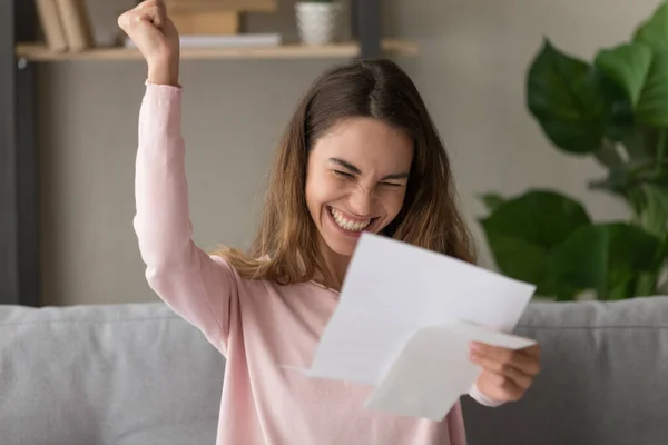 Überglückliche junge Frau ist euphorisch, als sie in Brief gute Nachrichten liest — Stockfoto