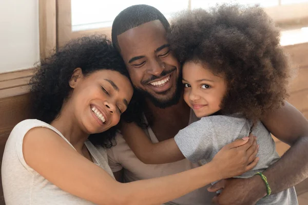Happy african American couple with child embrace at home — ストック写真