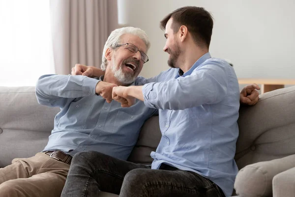 Happy old father and son fists bumping, celebrating success — Stock Photo, Image