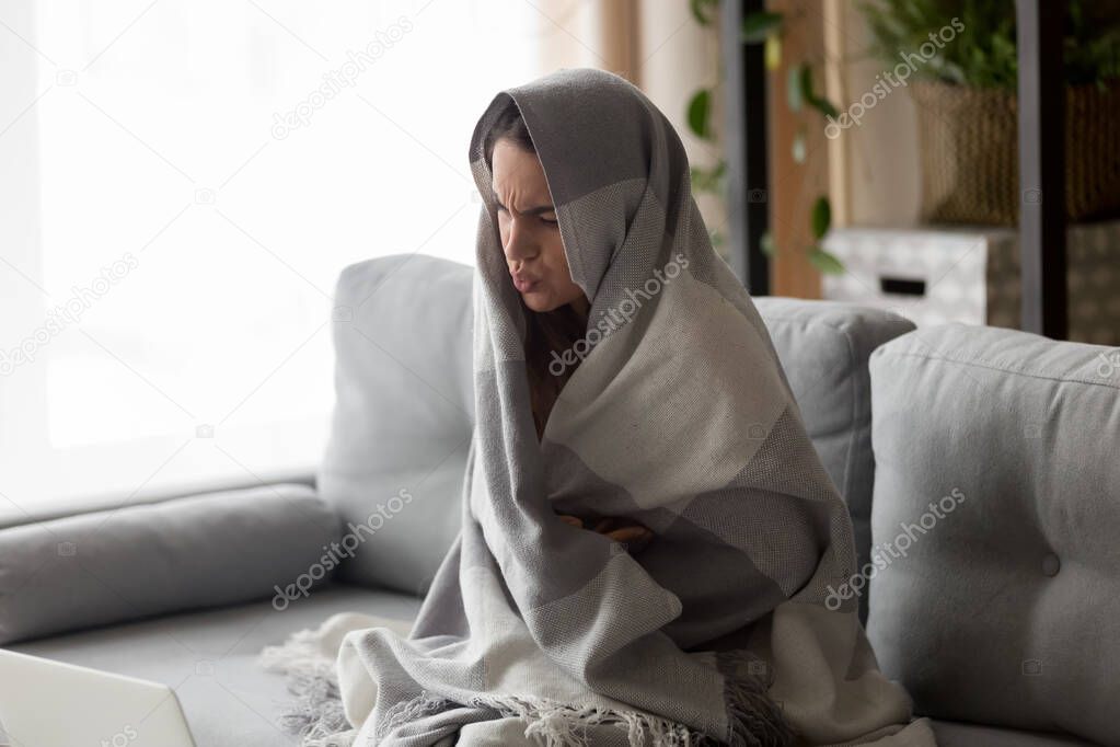 Ill girl wrapped in blanket suffering from cold