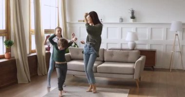 Mutlu bekar anne ve komik çocuklar evde dans ediyorlar.