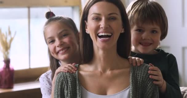 Schattige kinderen omarmen moeder van achteren, familie portret — Stockvideo