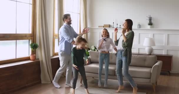 Crazy happy parents and children dancing jumping in living room — Stock Video