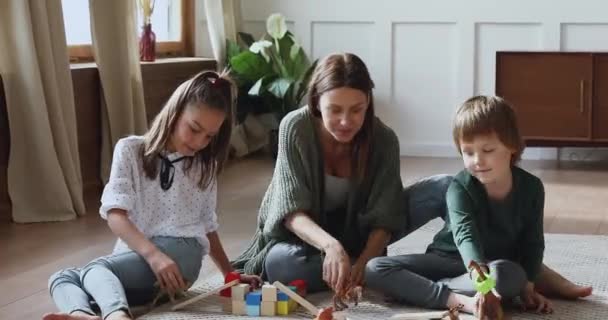 Cuidar mamãe brincando de brinquedos no chão com as crianças em casa — Vídeo de Stock
