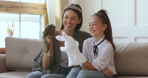 Счастливая мать и школьница играют в кукольный театр дома — стоковое видео