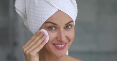 Sağlıklı, mutlu, güzel bir bayan yüz bakımı süngeri tutuyor.