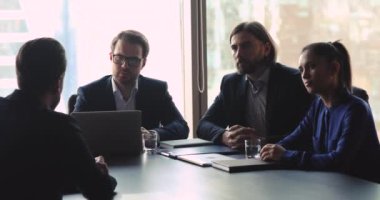 Ciddi insan kaynakları ekibi erkek iş başvurusu yapanı sorguluyor.