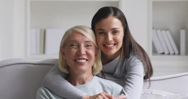 Feliz dos generaciones de mujeres abrazando abrazos mirando a la cámara — Vídeo de stock