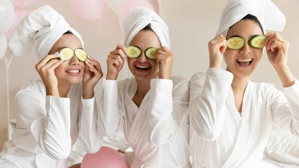 Gelukkig jonge vrouwen maken komkommer masker ontspannen samen met ballonnen — Stockfoto