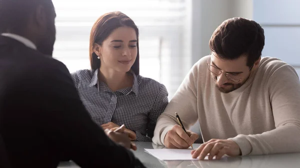 Caucasian couple sign documents close deal with biracial agent — Stock Photo, Image