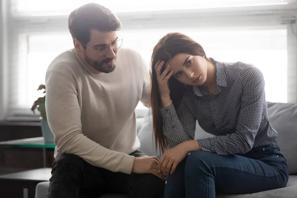 Joven marido hacer las paces con infeliz esposa ofendida — Foto de Stock