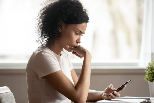 Pensive african American woman lost in thoughts using cellphone — Stock Photo, Image