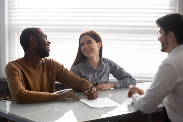 Excited multiethnic couple closing deal with banker specialist in office — Stock Photo, Image