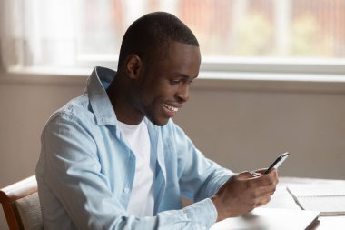 Gülümseyen melez adam modern akıllı telefon mesajları kullanıyor.