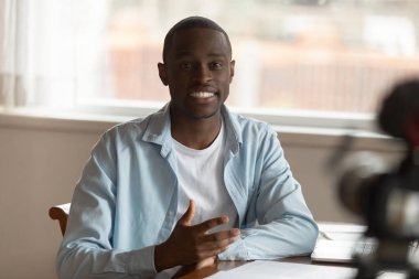 Motive olmuş Afrikalı Amerikalı adam kamera karşısında konuşuyor.