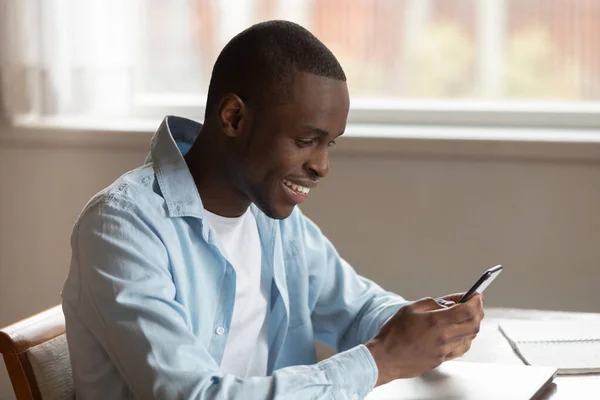 Sonriente hombre biracial utilizando mensajes de texto de teléfonos inteligentes modernos — Foto de Stock