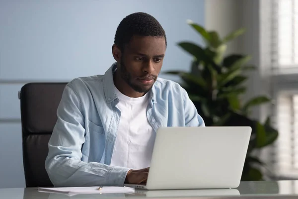 Ofiste dizüstü bilgisayarda çalışan Afrikalı Amerikalı erkek çalışan. — Stok fotoğraf