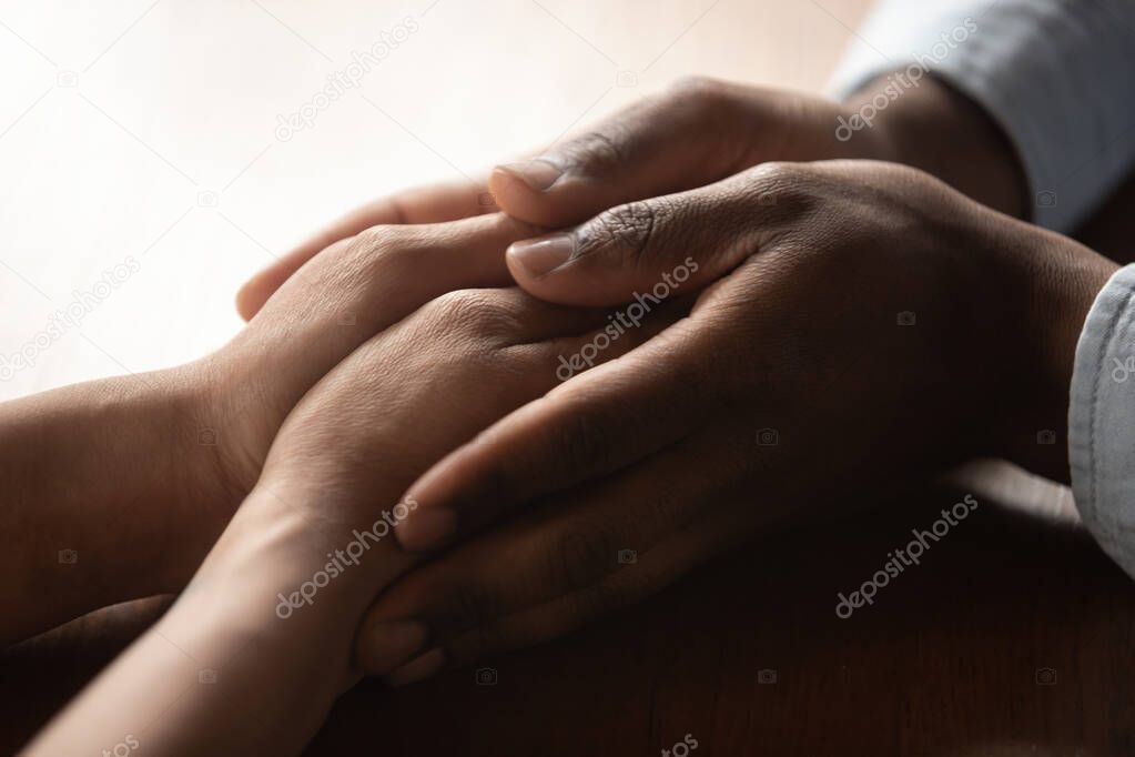 African American couple hold hands enjoying tenderness