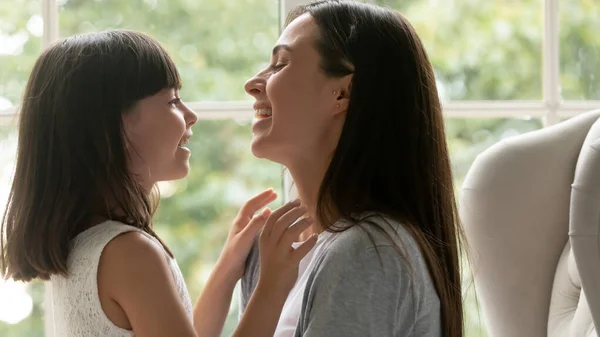 Hija hablando con joven hermosa madre pasar tiempo juntos en el interior —  Fotos de Stock