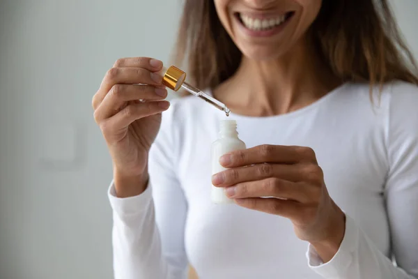 Young woman holding bottle with collagen moisturizer face serum — Stock Photo, Image