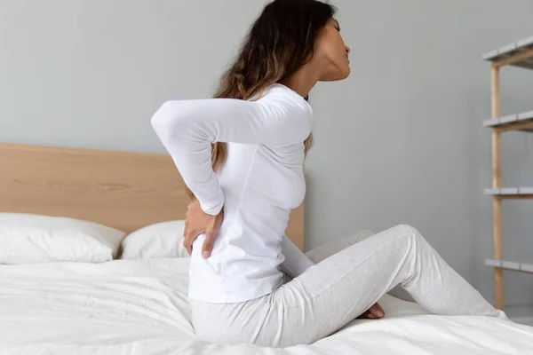 Mujer mientras despierta siente sentimientos dolorosos en la espalda baja — Foto de Stock