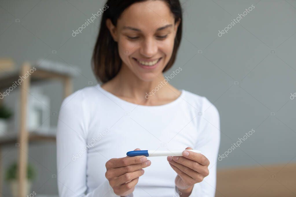 Woman holding digital pregnancy test closeup focus on arms