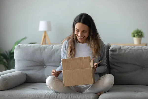 Alegre joven mujer abre paquete caja se siente satisfecho —  Fotos de Stock