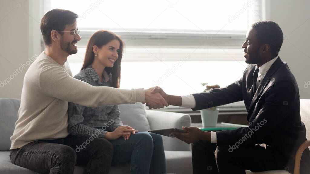 Caucasian clients couple handshake male agent at meeting