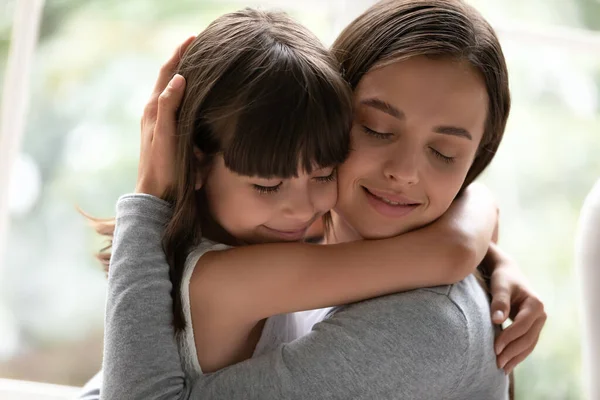 Madre e piccola figlia coccole avendo forti legami primo piano vista — Foto Stock