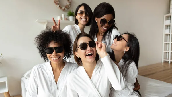Wanita muda ceria tertawa melihat kamera memakai kacamata hitam jubah mandi — Stok Foto