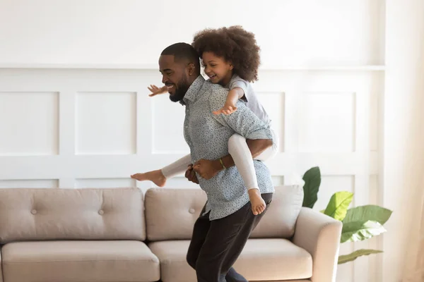 Feliz biracial hija piggyback jugar con joven papá —  Fotos de Stock