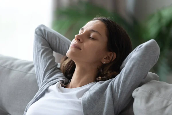 Close-up serene vrouw gezicht gesloten ogen leunde op bank binnen — Stockfoto