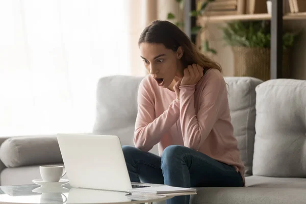 Chockad kvinna överraskad av oväntat meddelande på laptop — Stockfoto