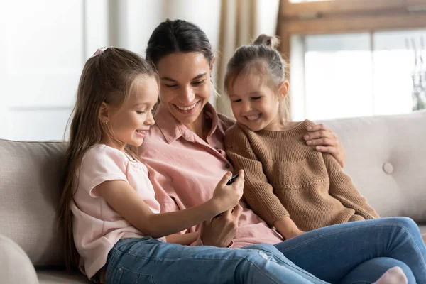 Happy mom and kids daughters using looking at cell phone — Stock Photo, Image